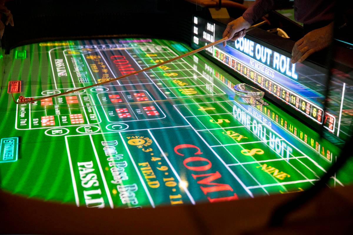 Bordsspelhandlare Alan Green hanterar tärningar på det nya digitala crapsbordet, Rolls to Win Craps, en ...